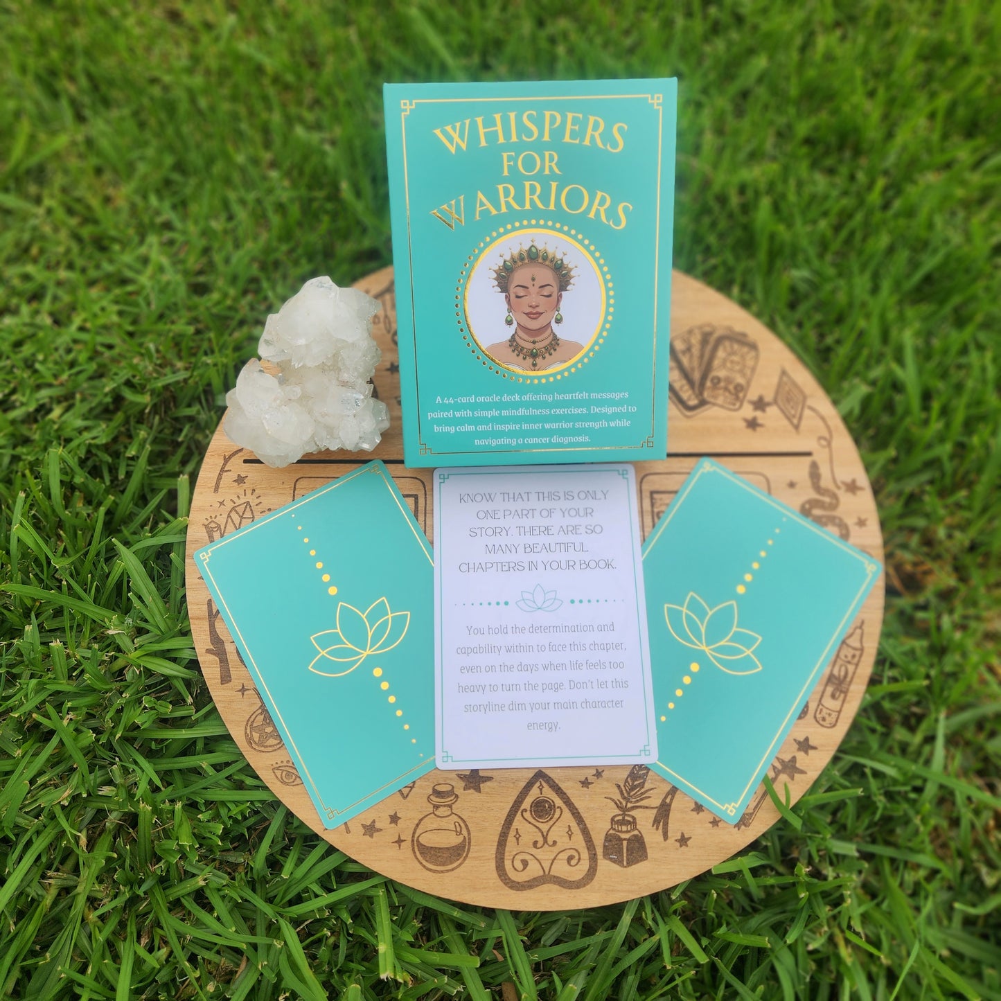 Turquoise cards with gold text and illustrations on a wooden board with grass background

