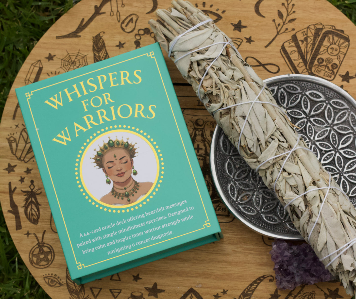 cover of Whispers for Warriors oracle next to a bundle of sage